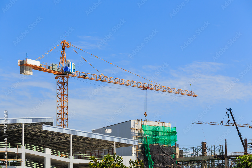 Construction site with cranes on sky background