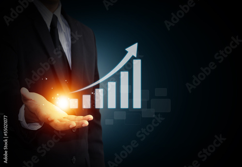 Hand holding a rising arrow, representing business growth.
