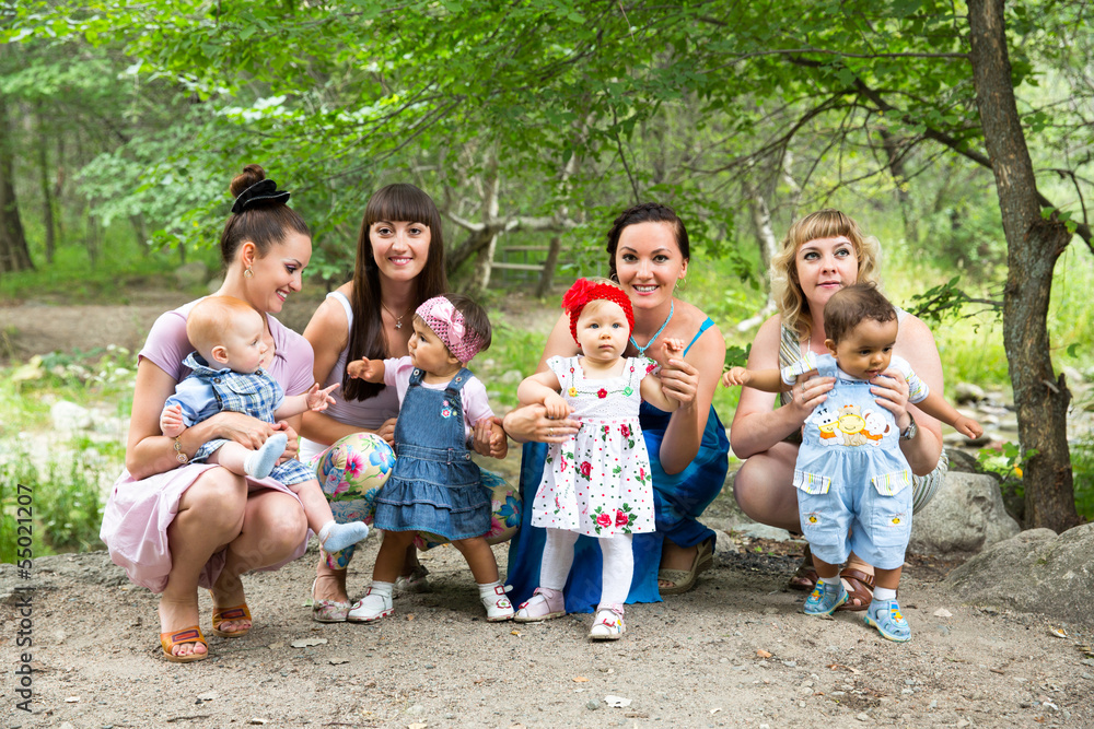 Fototapeta premium Four Happy Beautiful Mothers and children hugging and laughing
