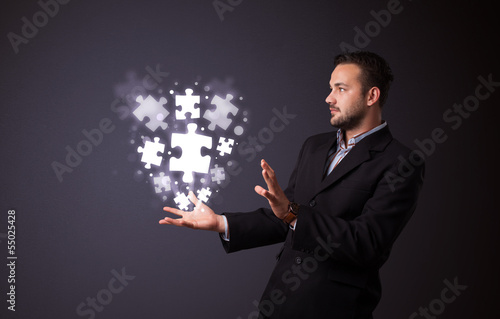 Puzzle pieces in the hand of a businessman