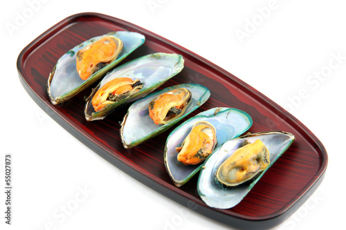 Mussels on wooden dish.