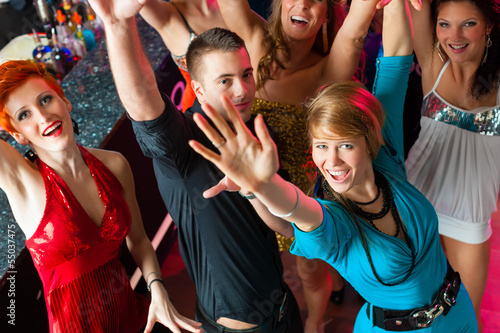 Young people dancing in club or disco, men and women