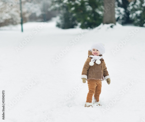 Smiling baby walking in winter park