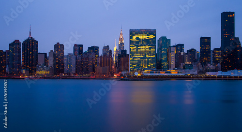 the buildings of manhattan at night in front of east river © malkolm
