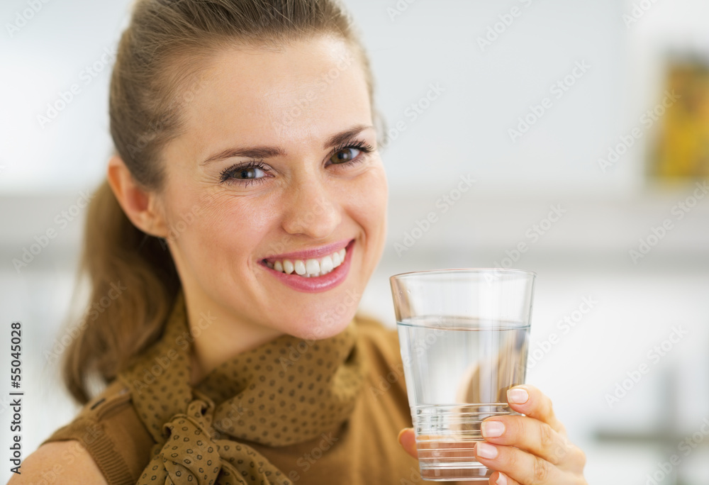 Portrait of happy young woman drinking water in kitchen Portrait of happy young woman drinking water in kitchen