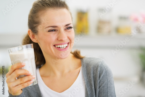 Smiling young woman drinking fresh cocktail
