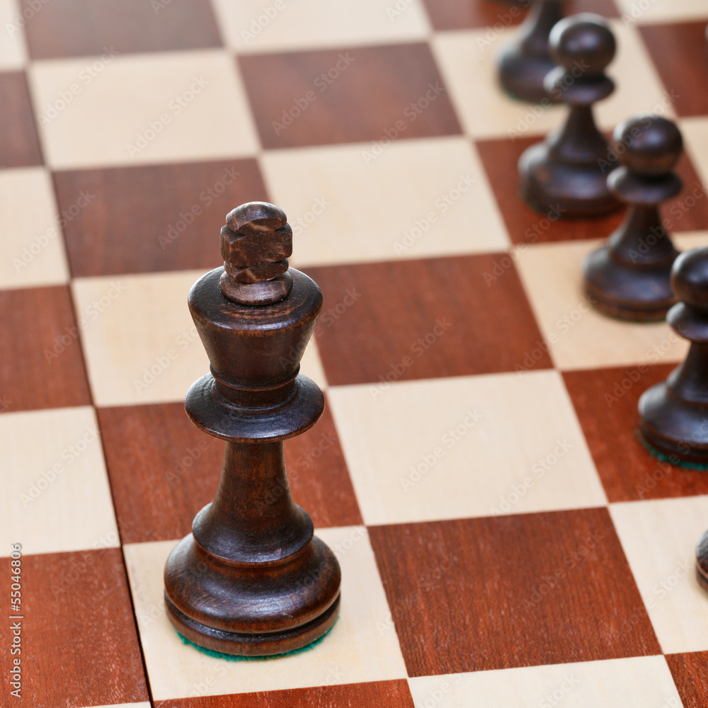 Black chess king in front of pawns Black chess king in front of pawns