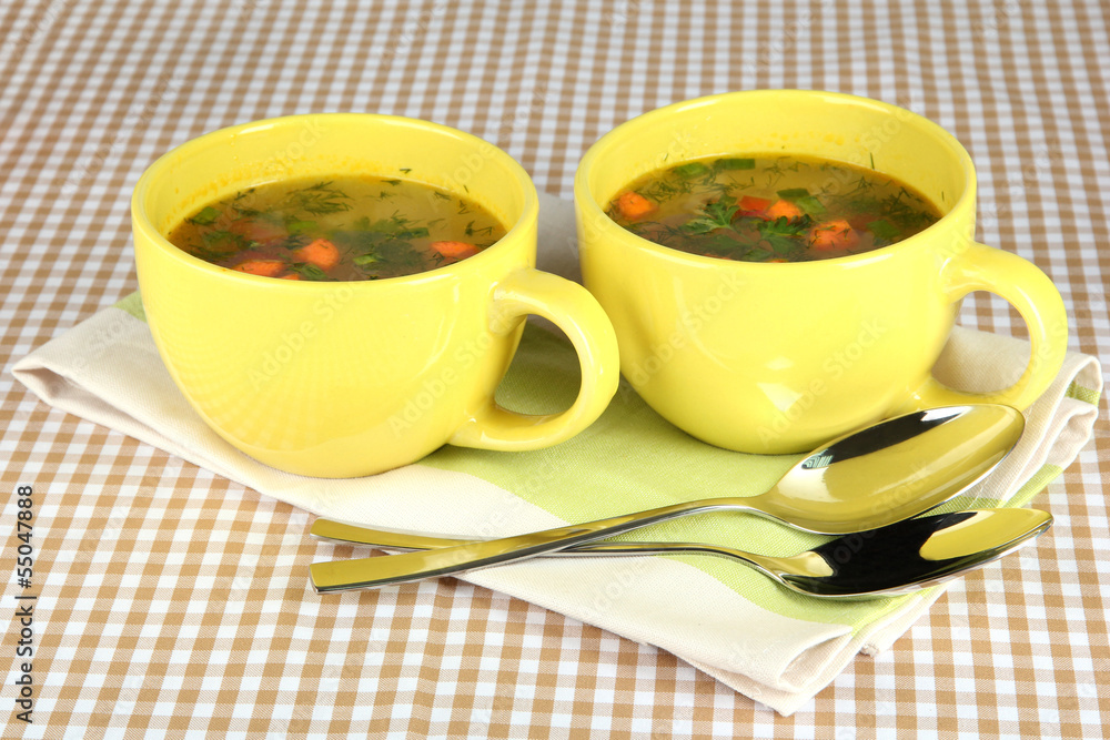 Fragrant soup in cups on table in kitchen