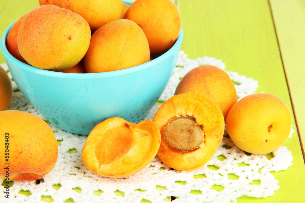 Fresh natural apricot in bowl on green wooden table Fresh natural apricot in bowl on green wooden table