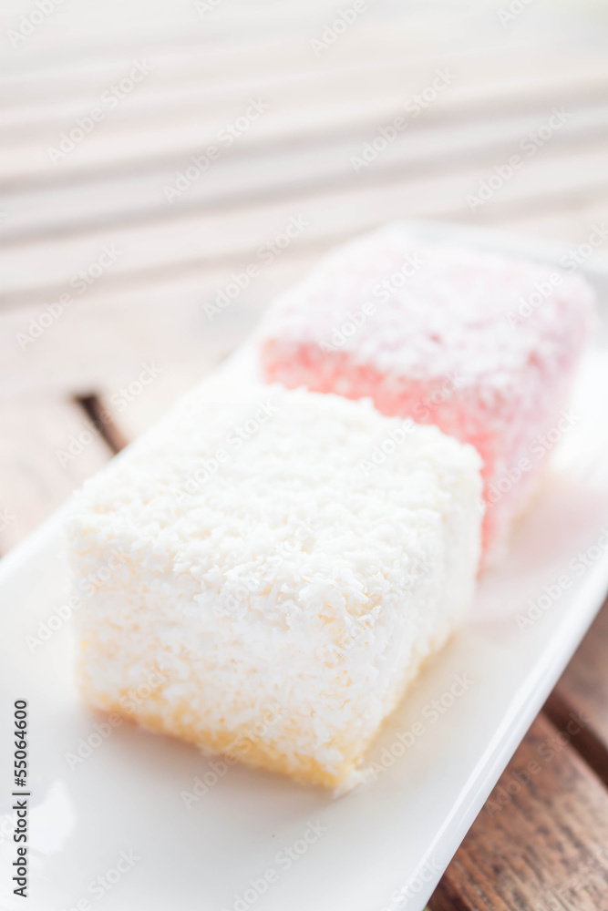 Pink and white lamington cakes on wood table