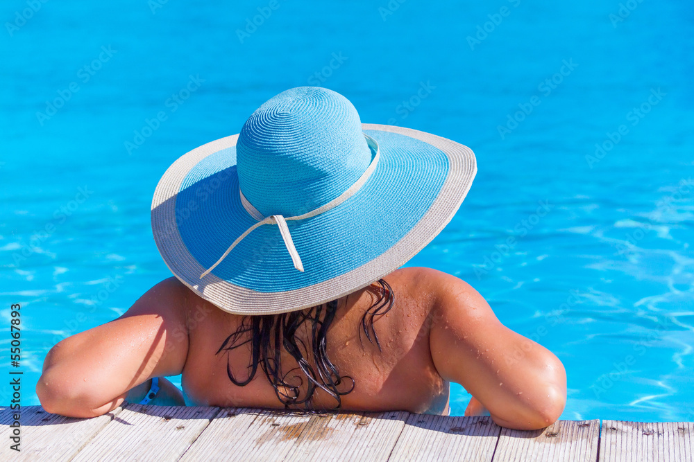 Woman in hat relaxing at swimming pool in Greece Stock Photo