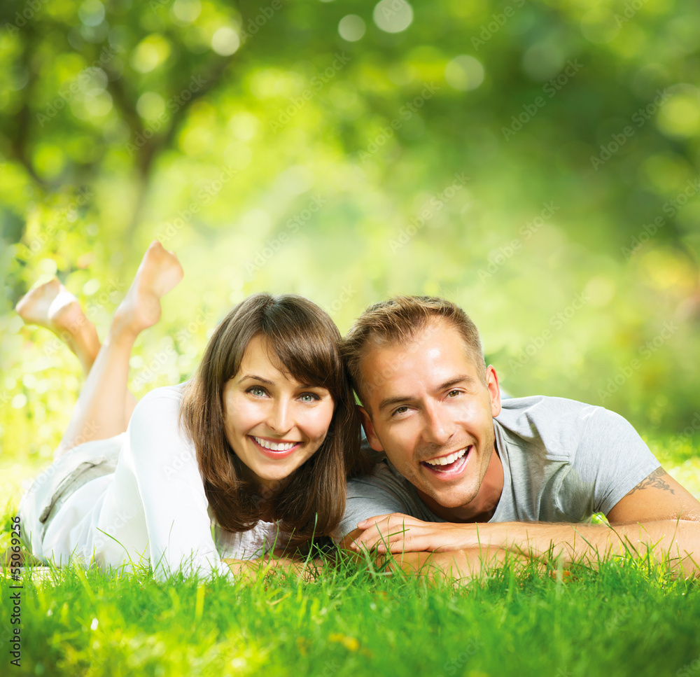 Happy Smiling Couple Together Relaxing on Green Grass Outdoor Happy Smiling Couple Together Relaxing on Green Grass Outdoor