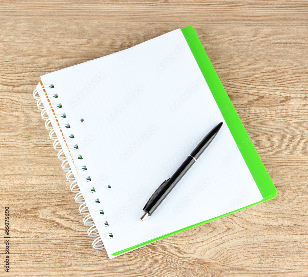 Notebook and pen on wooden table Notebook and pen on wooden table