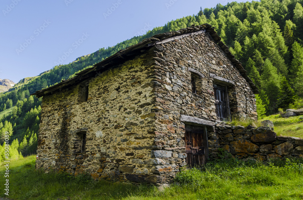 The ancient peasant stone house in the Alps The ancient peasant stone house in the Alps