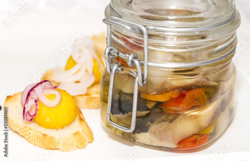 herring in a glass jar on a table in a restaurant photo