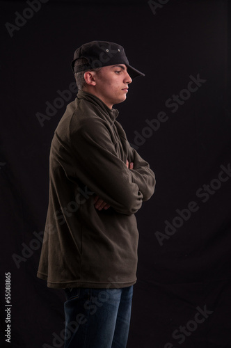 serious teenager try to be cool standing with the cap put on one