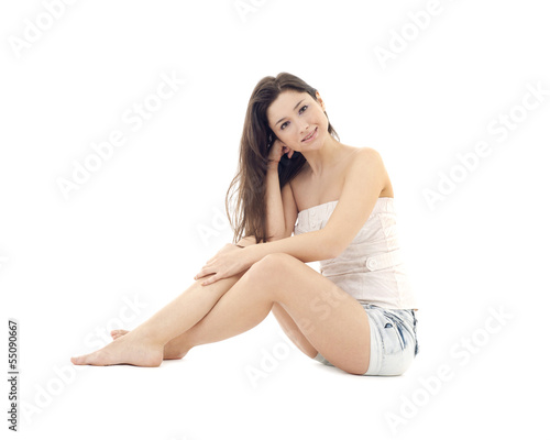 pretty young woman sitting on a floor isolated on white