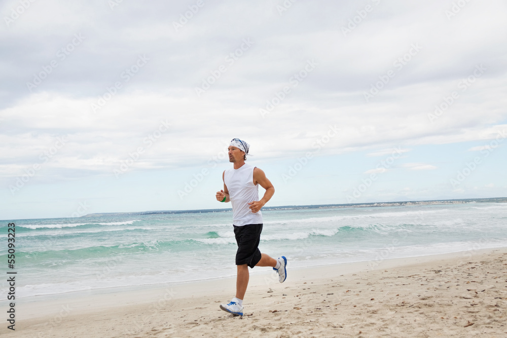erwachsener sportlicher mann jogger am strand erwachsener sportlicher mann jogger am strand