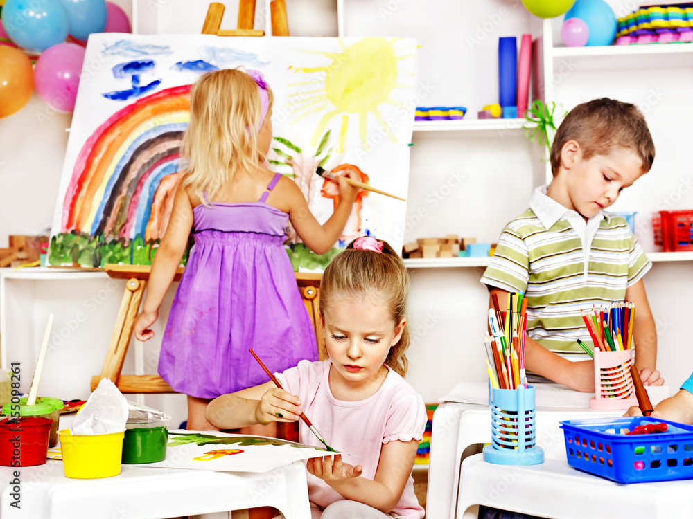 Fototapeta premium Child painting at easel.