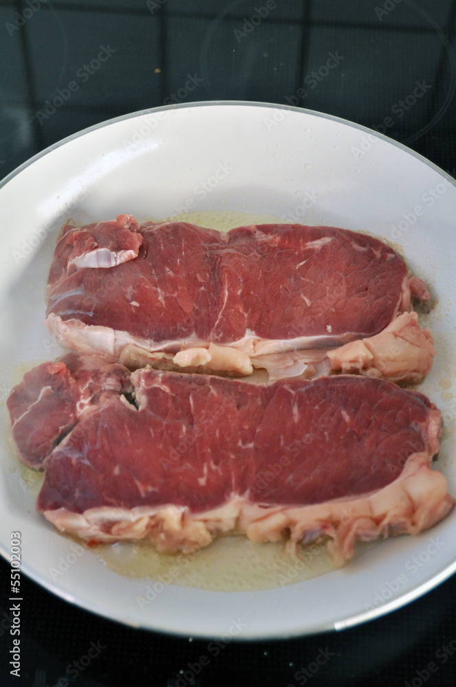 Rohes Rumpsteak in der Pfanne Rohes Rumpsteak in der Pfanne