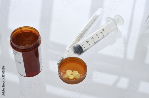 pills with pill bottle and syringe photo