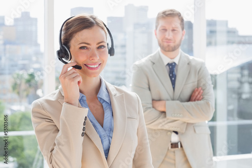 Happy call centre agent with colleague behind her