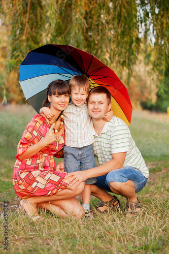 Father, mother and son with colorful umbrella. © Vitalinka