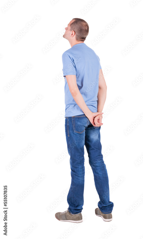 Back view of young man in t-shirt and jeans looking. Back view of young man in t-shirt and jeans looking.