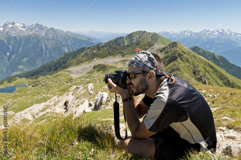 Young photographer taking landscape pictures in the mountains