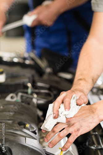 Car mechanic wiping his dirty hands
