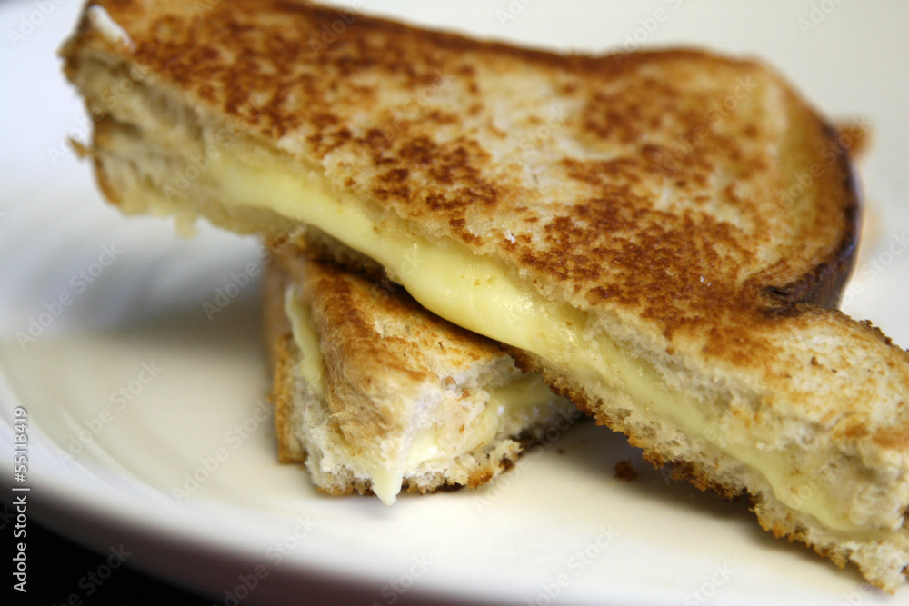 Oozing grilled cheese sandwich on white plate Oozing grilled cheese sandwich on white plate