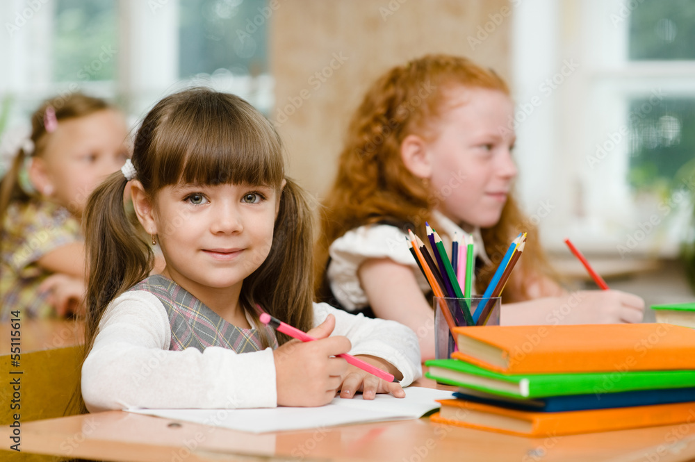 Portrait of lovely girl drawing in copybook and looking at camer Portrait of lovely girl drawing in copybook and looking at camer