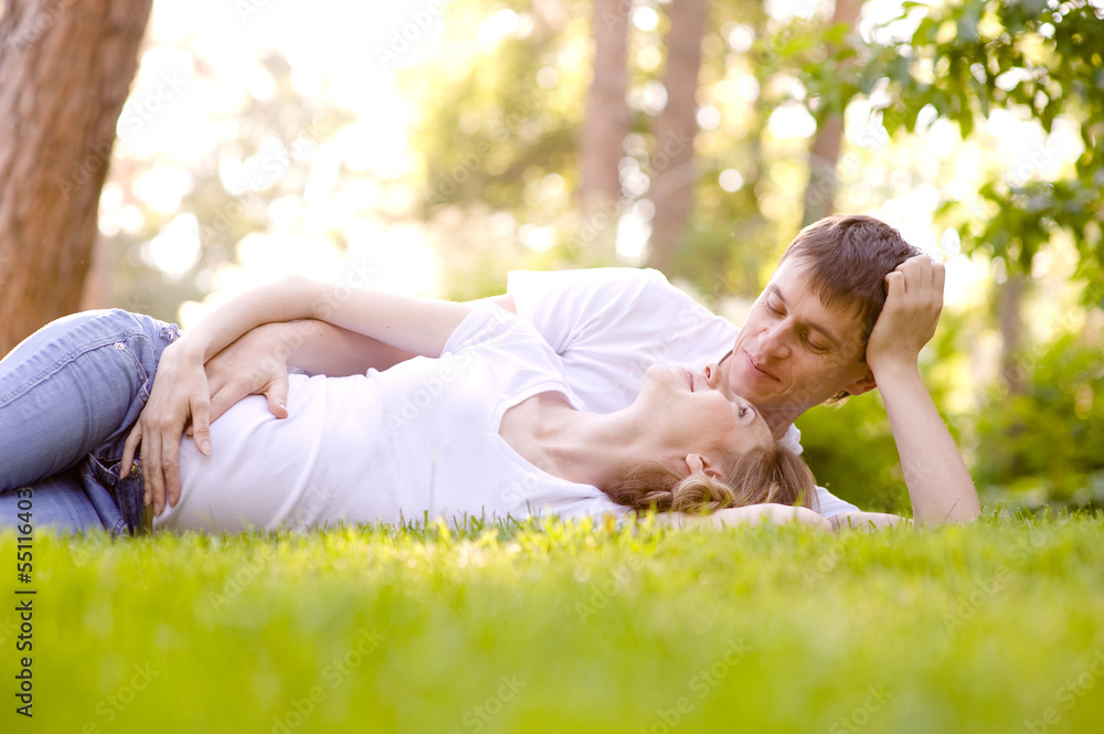 Happy Smiling Couple Relaxing on Green Grass