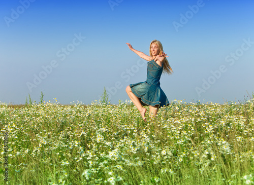 The happy young woman jumps in the field  of camomiles © Konstantin Kulikov