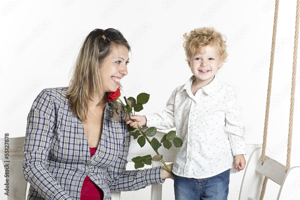 Cute toddler is giving his mother a flower Cute toddler is giving his mother a flower