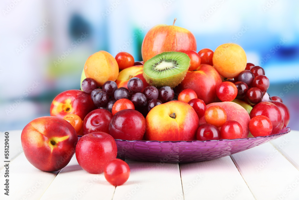 Assortment of juicy fruits on wooden table, on bright Assortment of juicy fruits on wooden table, on bright