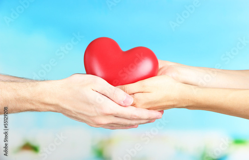 Heart in hands on cloud background