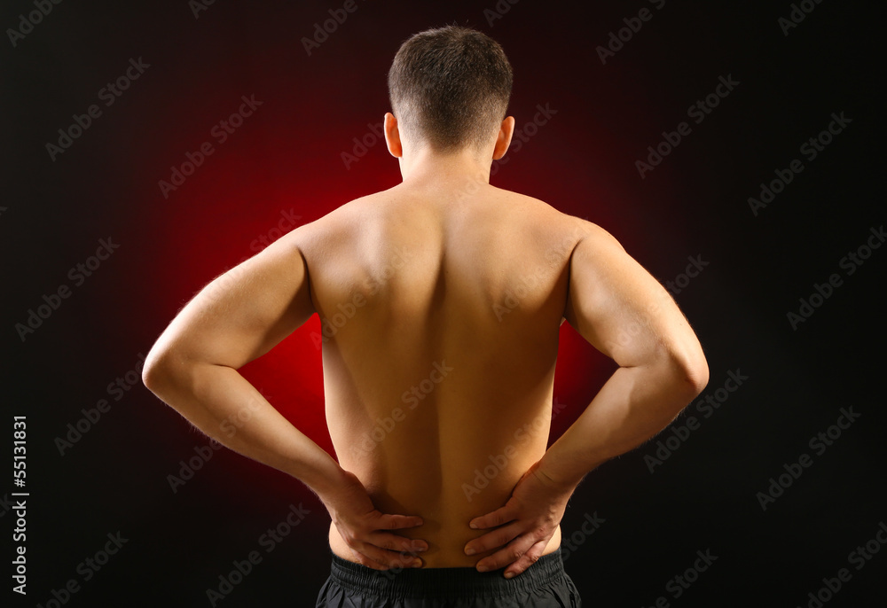 Young man with back pain, on red background Young man with back pain, on red background