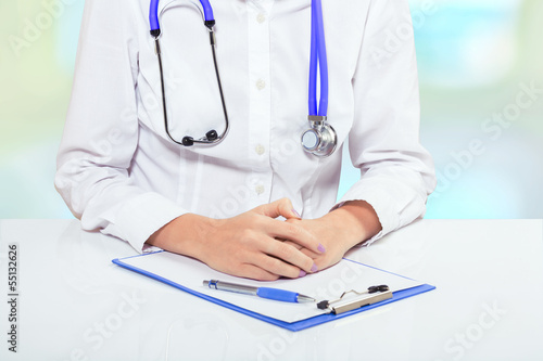 a doctor at the table with clipboard very closeup