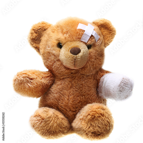 Photo Classic teddy bear with bandages isolated on white background