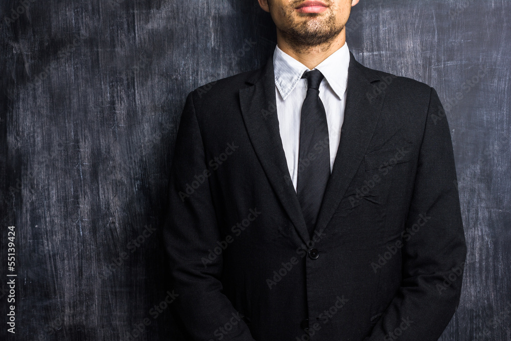 Businessman in front of blank blackboard Businessman in front of blank blackboard