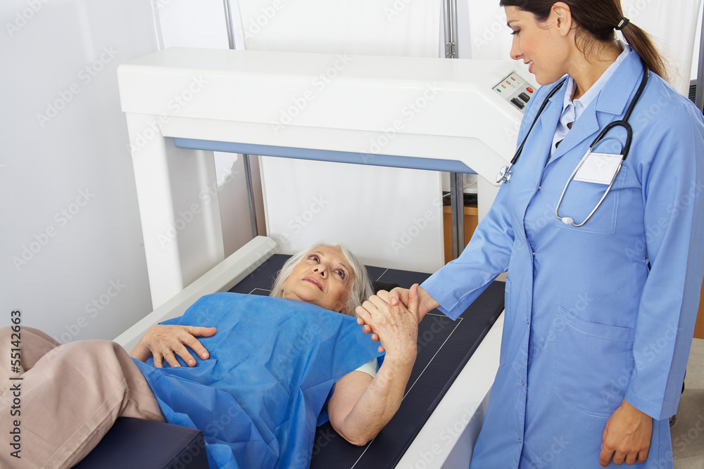 Seniorin hält Hand einer Ärztin in Radiologie Seniorin hält Hand einer Ärztin in Radiologie