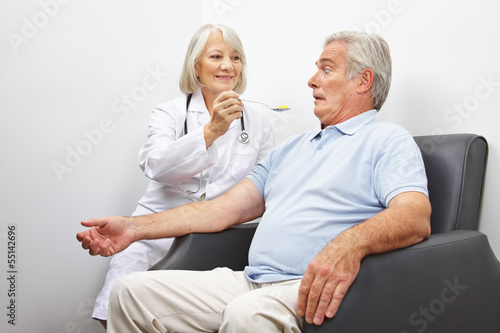 Arzt füttert Patient mit Tabletten