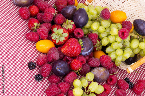 Fototapeta Naklejka Na Ścianę i Meble -  tasty summer fruits on a red tablecloth
