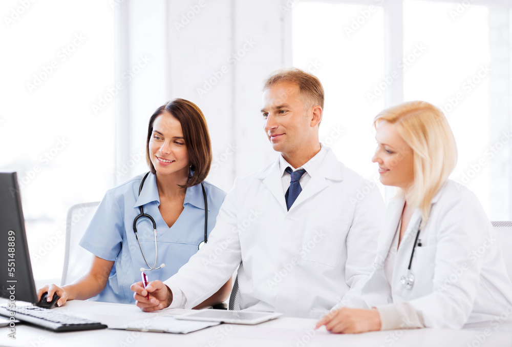 doctors looking at computer on meeting doctors looking at computer on meeting
