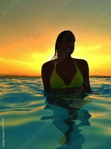 woman in pool at sunset