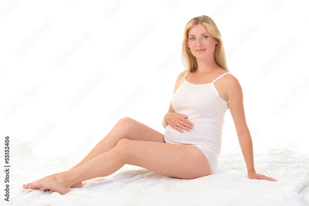 young pregnant woman sitting on a white blanket young pregnant woman sitting on a white blanket