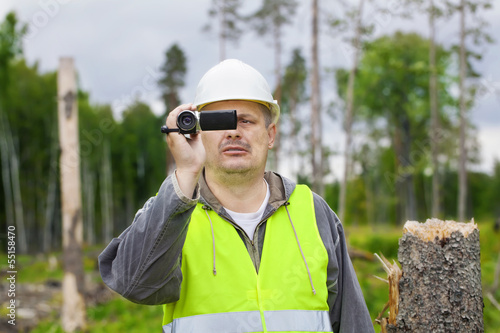 Forest Officer with camcorder in destroyed forest