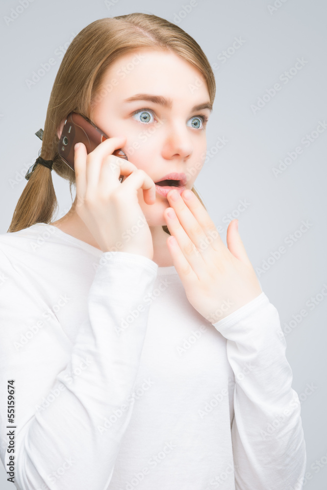 shocked teenage girl speaking on mobile phone. isolated shocked teenage girl speaking on mobile phone. isolated