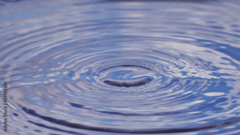 Water drops in slow motion, reflection of blue cloudy sky Water drops in slow motion, reflection of blue cloudy sky